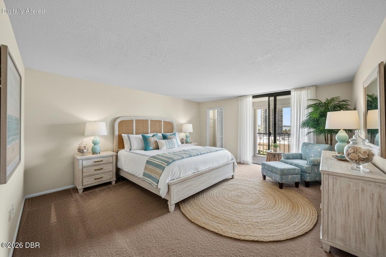 Bedroom with a king bed, blue accent chair, and balcony doors.