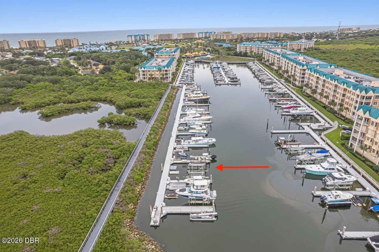 Aerial view of a marina, with a red arrow pointing to a dock slip.