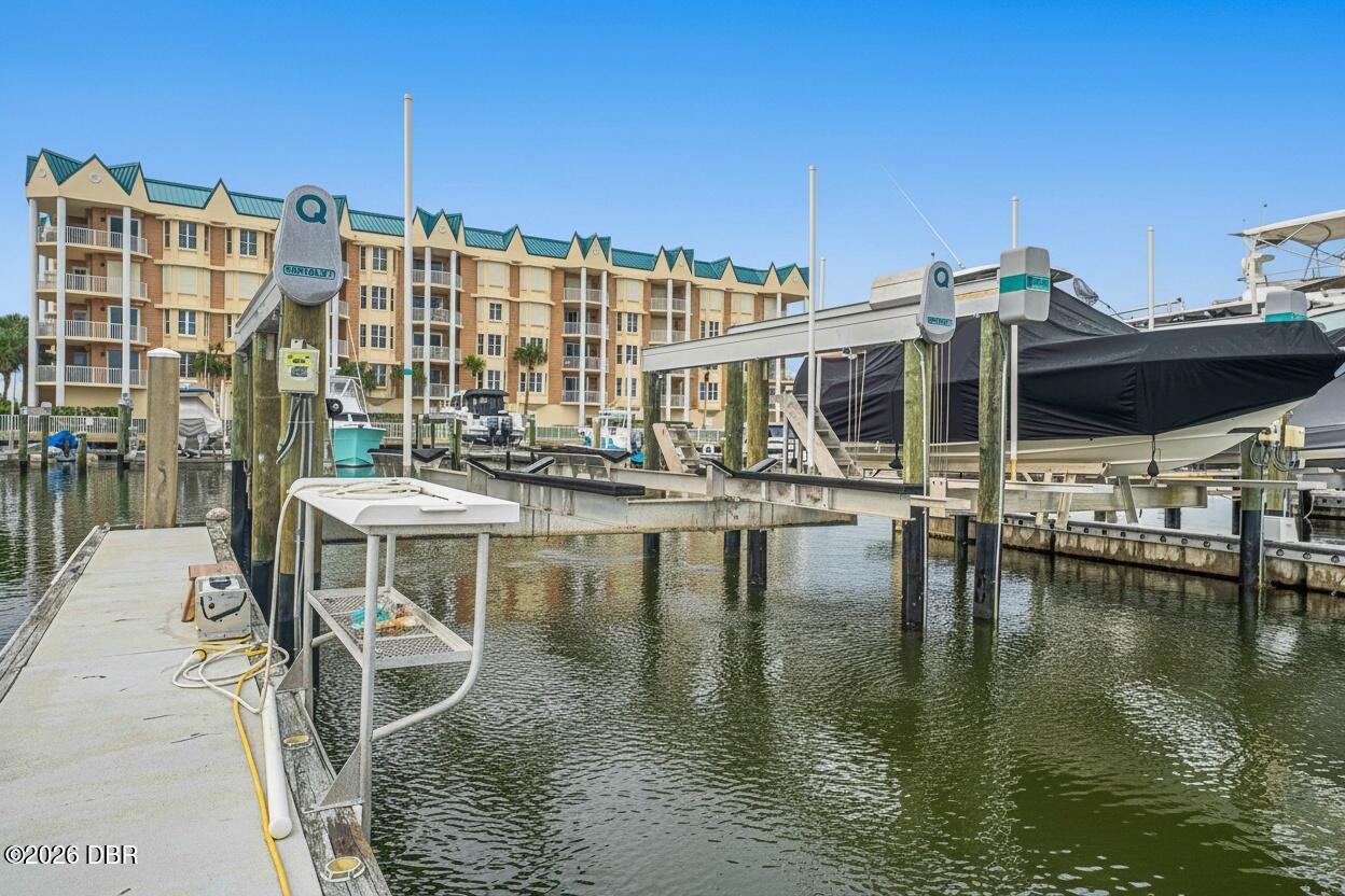 Marina with docked boats and a multi-story condominium building behind the slips.