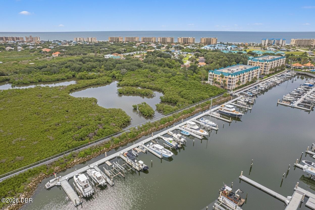 Aerial view of a marina, mangroves, coastal condos, and ocean.
