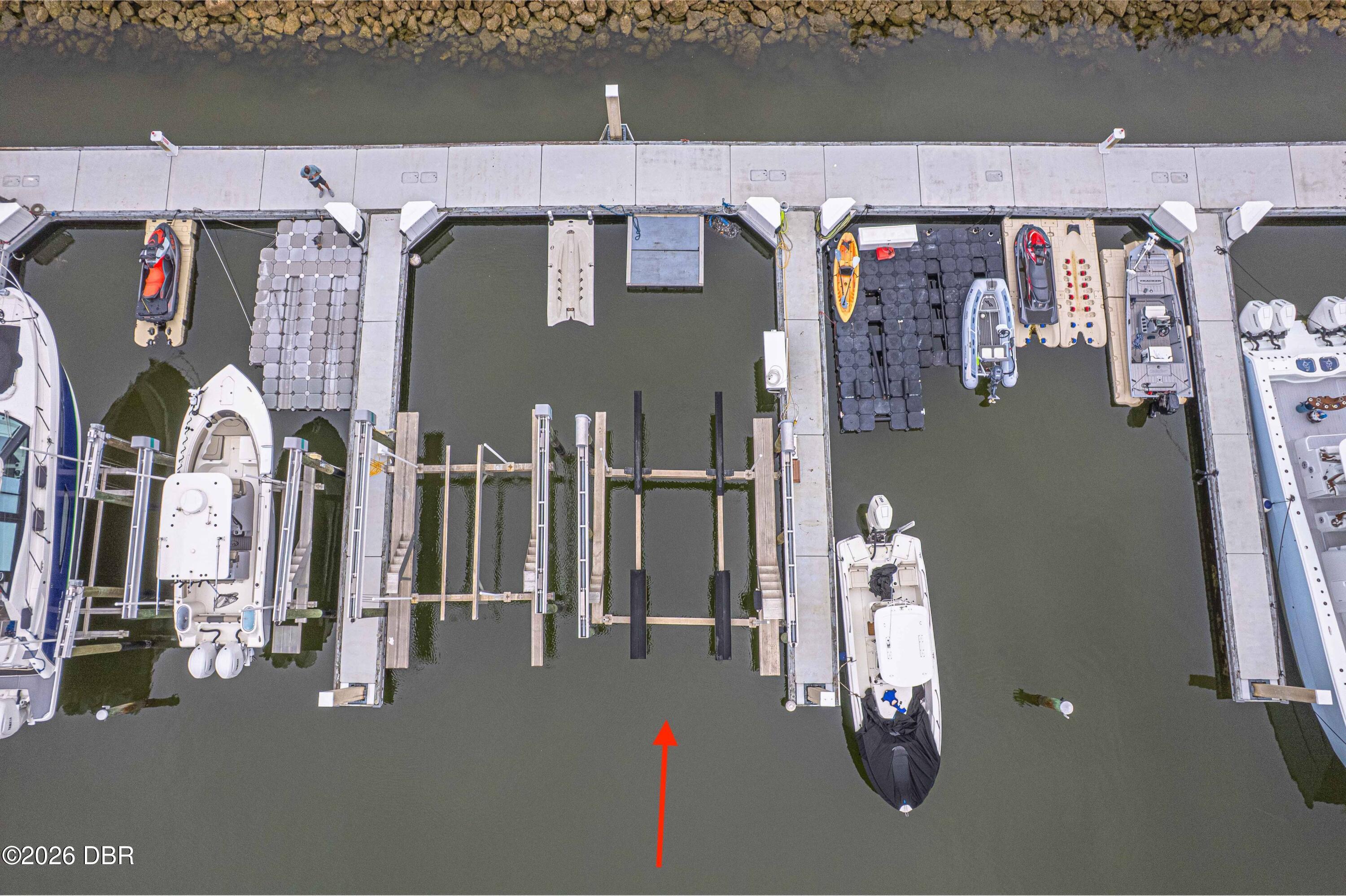 Aerial marina view with a red arrow pointing to an open boat slip.