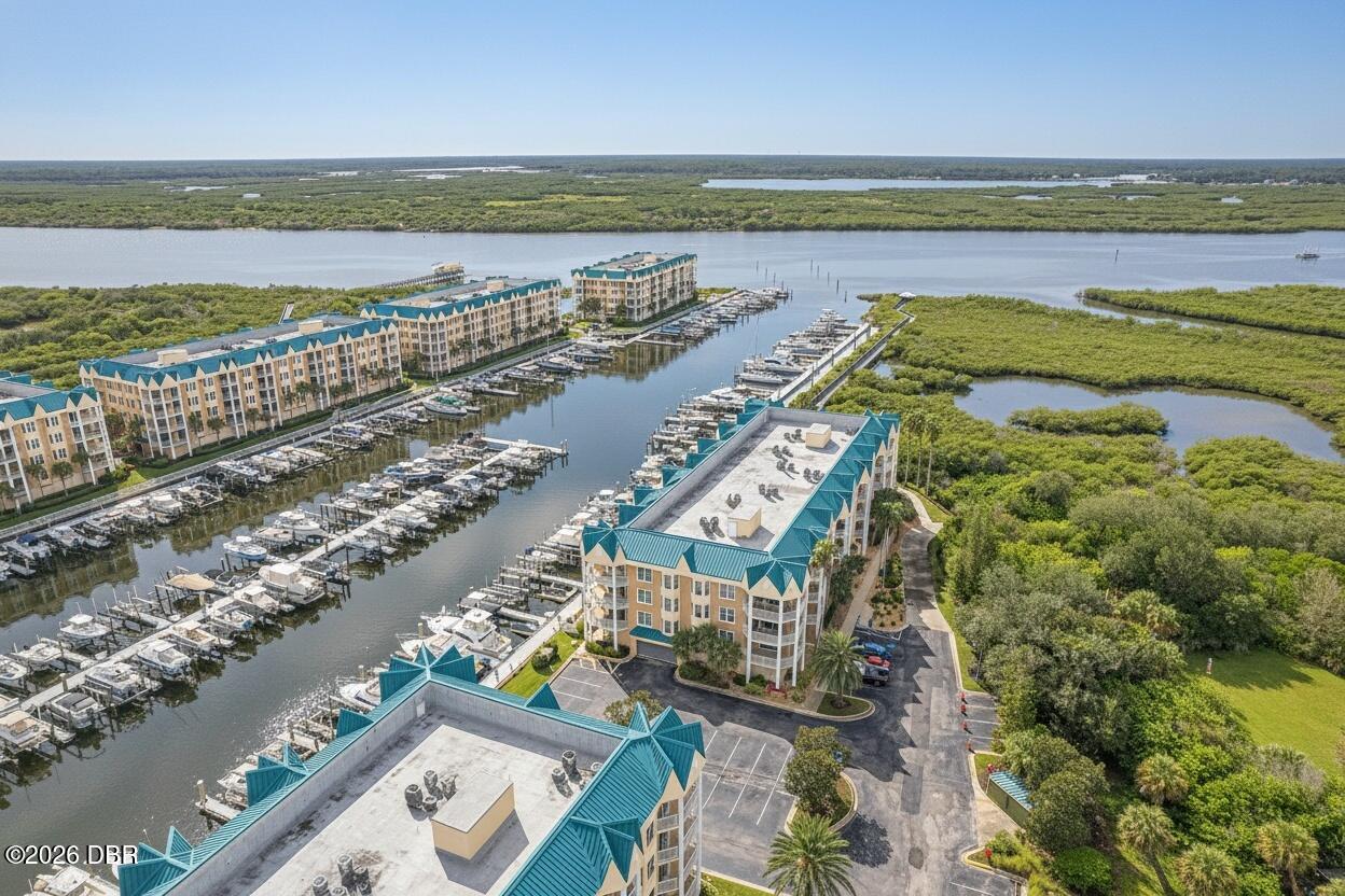 Aerial view of waterfront condos and marina surrounded by waterways and mangroves.