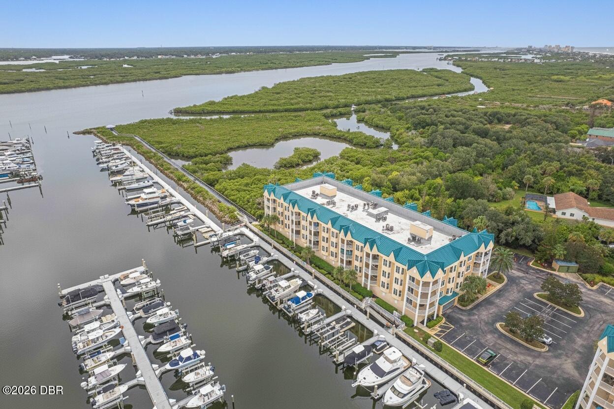 Waterfront condominium beside a marina, river, and surrounding marshland.