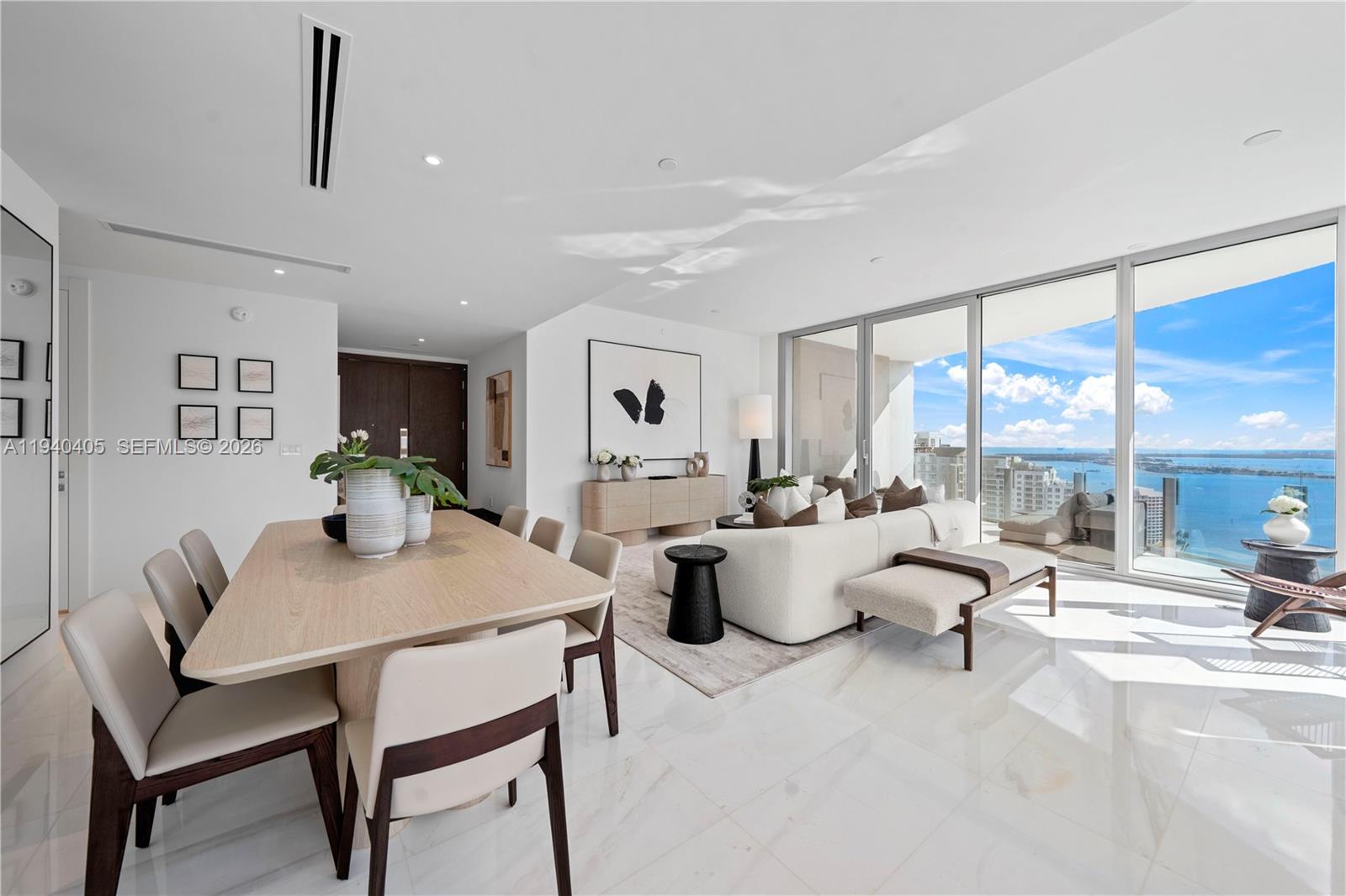 Open-plan living and dining room with floor-to-ceiling windows overlooking the bay and city.