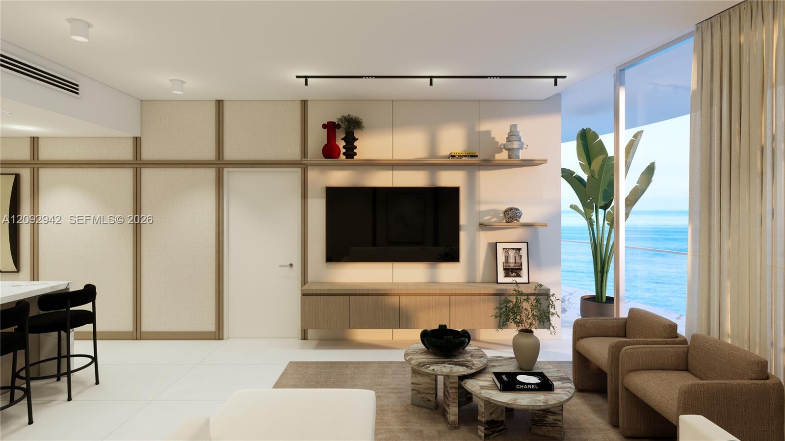 Modern living room with ocean views, built-in shelving, and neutral seating.