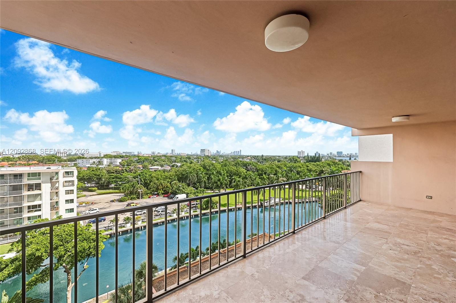 High-rise balcony overlooking a canal and distant city skyline.