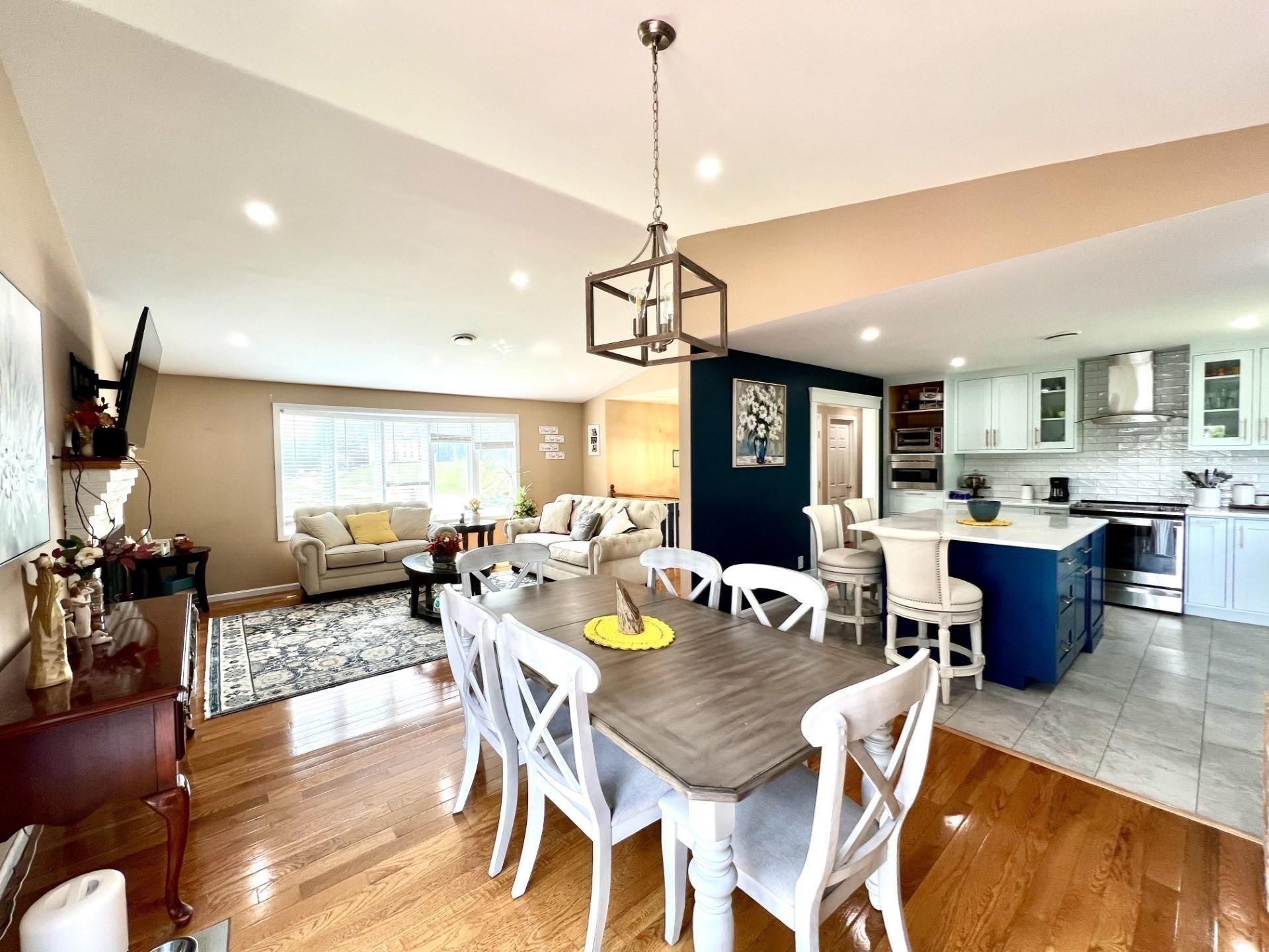 Open-plan dining and living area with a white kitchen and navy island.