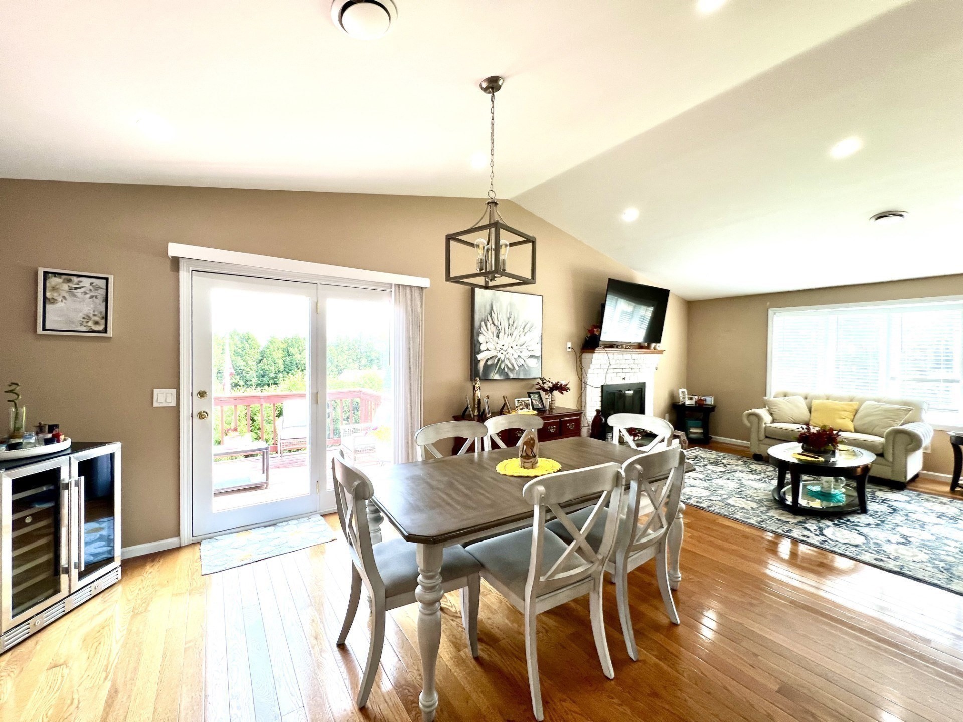Dining and living room with hardwood floors, sliding glass doors, and a fireplace.