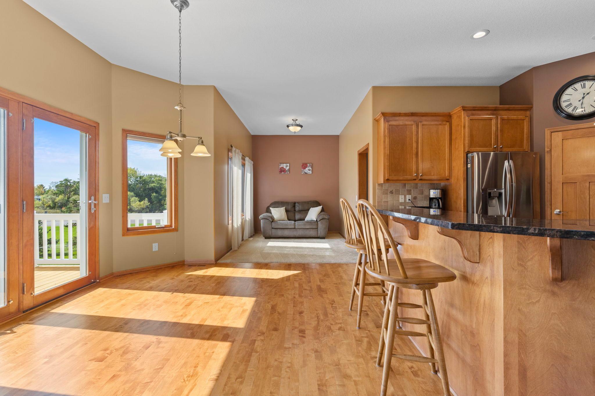 Open-plan kitchen and living area with a wood breakfast bar, large windows, and a sofa.