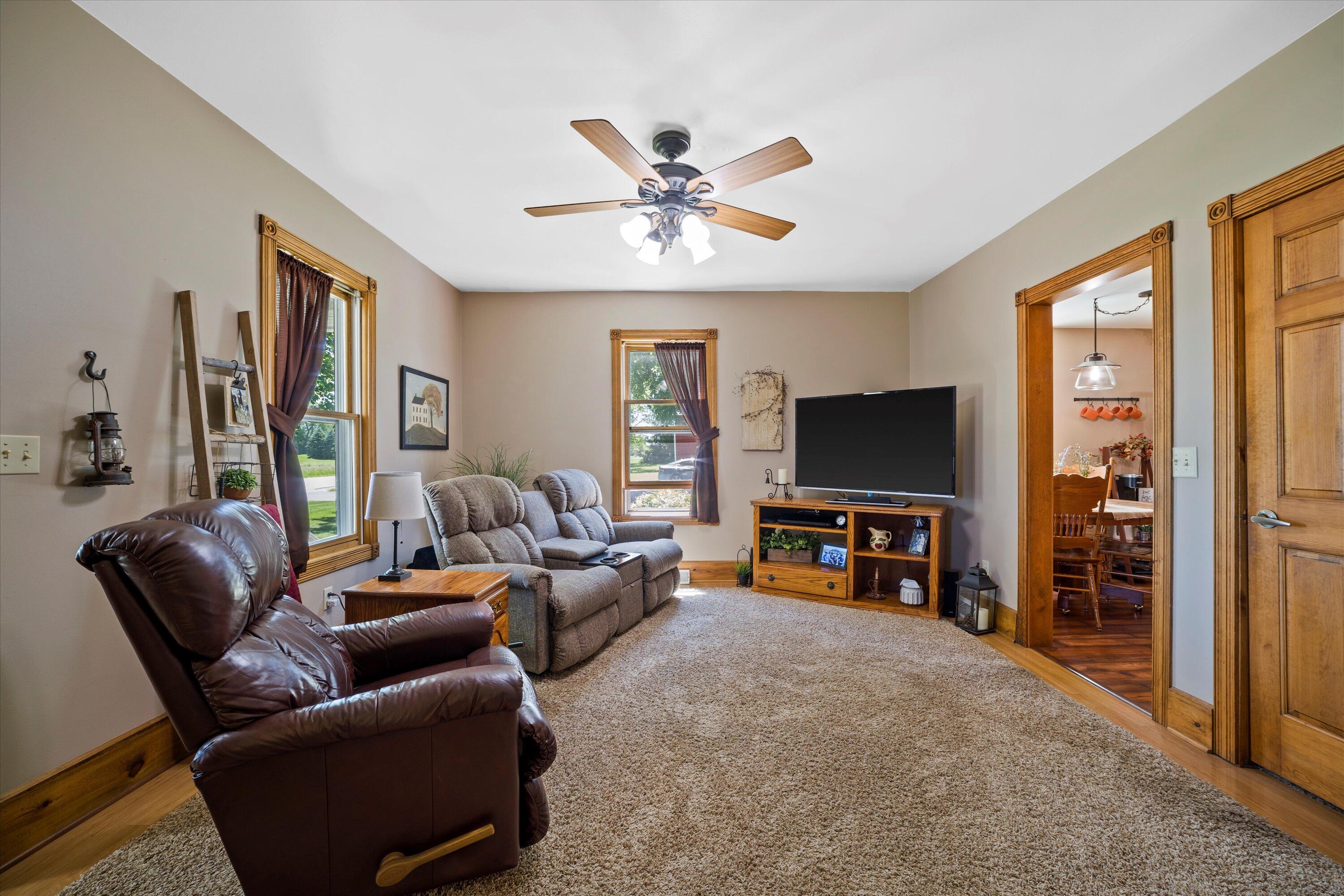 Furnished living room with a leather recliner, gray sofa, and wood-trimmed doorway to the dining room.
