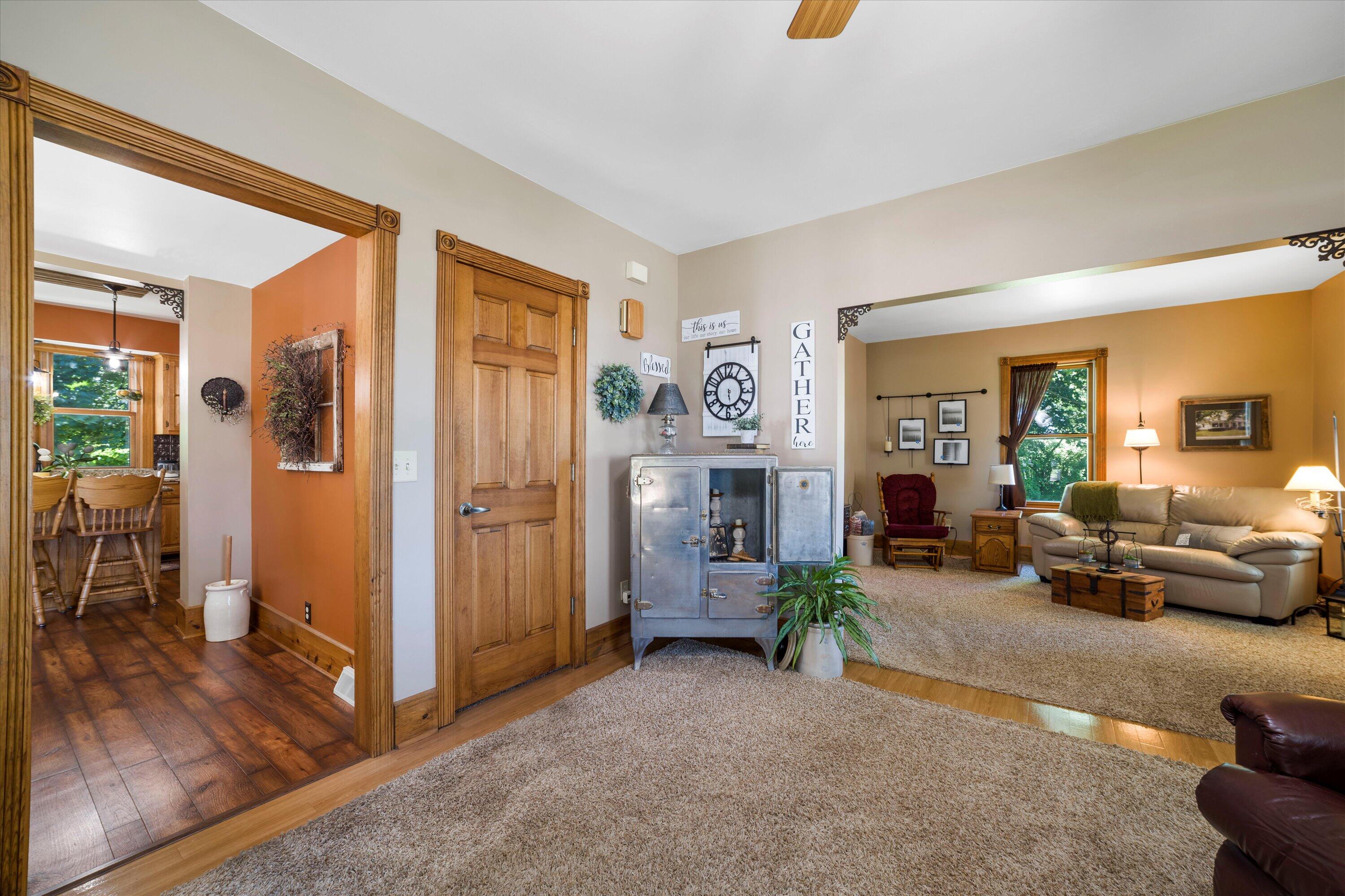 Furnished living room with a cream sofa, vintage metal cabinet, and view into the dining area.