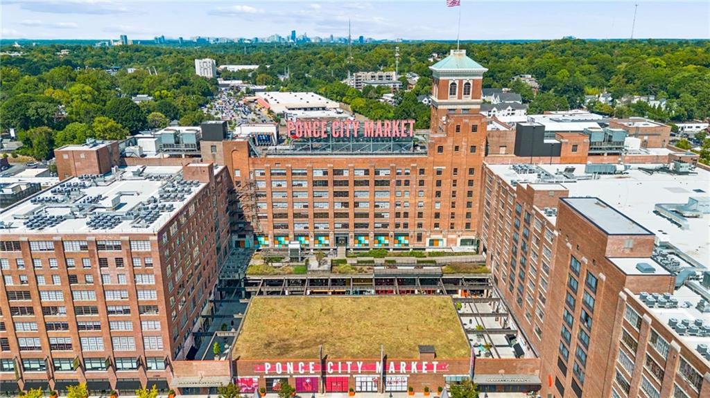 Ponce City Market’s red-brick complex and central tower, viewed from above with Atlanta’s skyline in the distance.