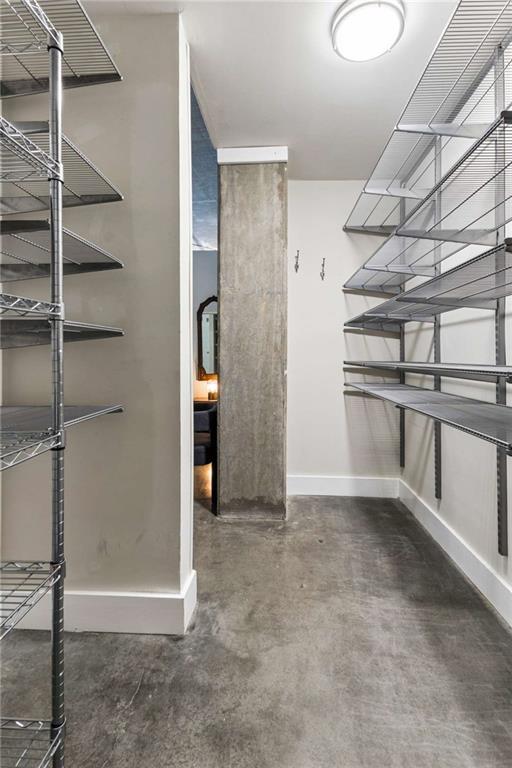 Walk-in closet with wire shelving along both walls and a polished concrete floor.