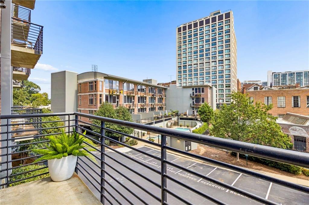 Condominium balcony overlooking a courtyard and tall city high-rise.