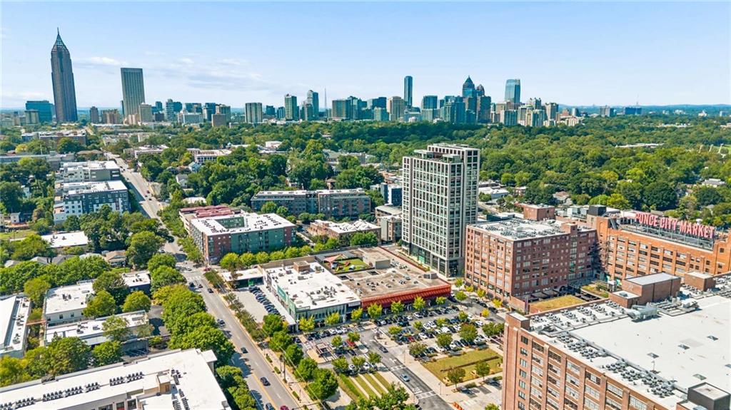 Aerial view of Atlanta’s skyline above tree-lined neighborhoods and nearby high-rise buildings.