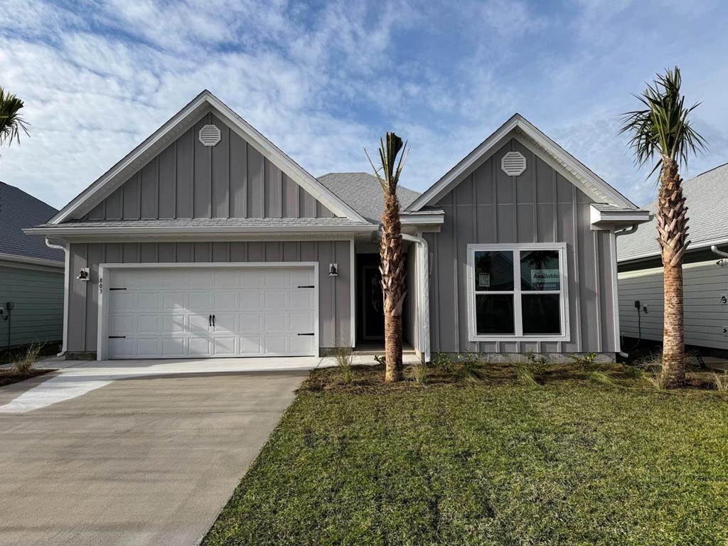 Gray single-story home with a double garage, two front gables, and palm trees.