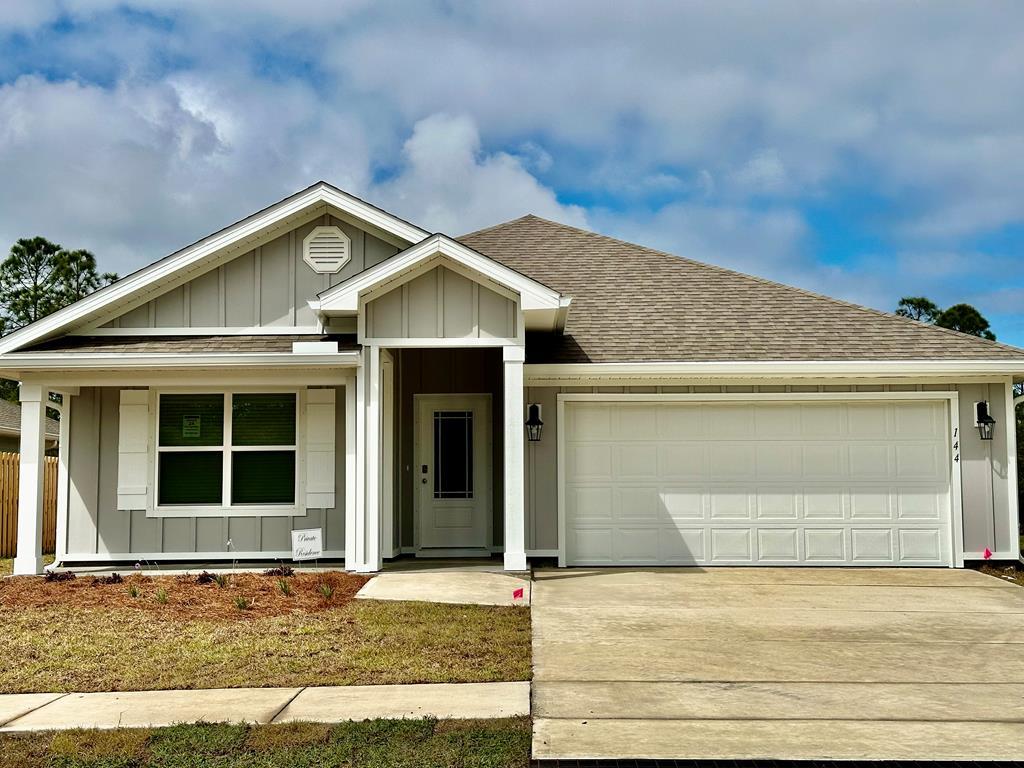Light gray single-story home with a covered entry and two-car garage.