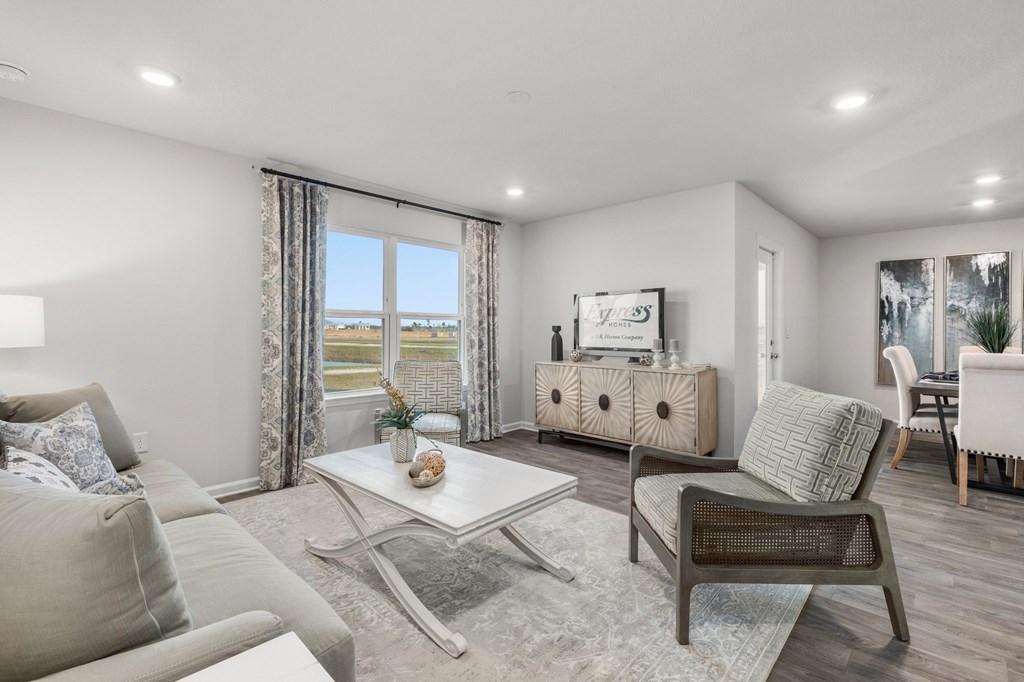 Staged living room with a patterned armchair and a window overlooking water.