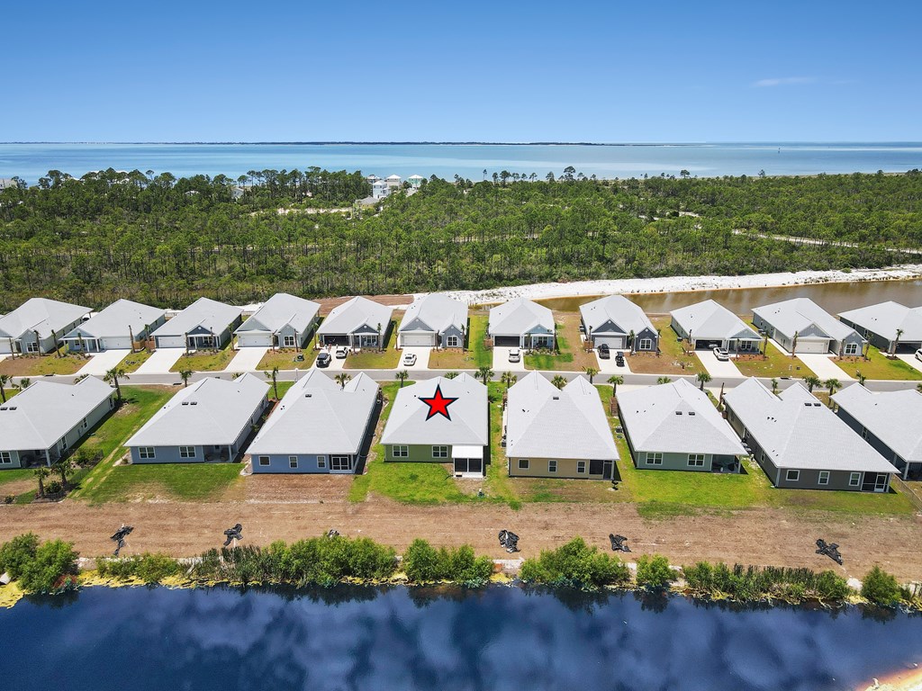 Aerial view of a red-starred home between a canal and coastal water