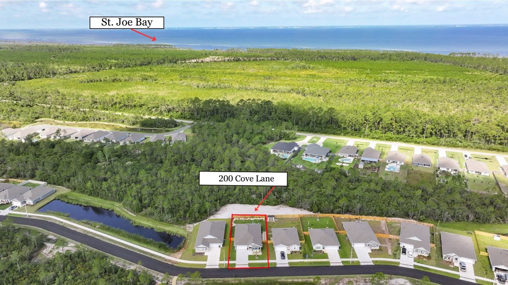 Aerial view of 200 Cove Lane, outlined in red, with St. Joe Bay in the distance.
