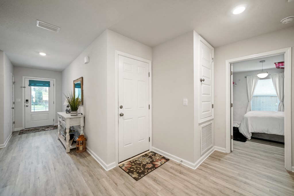 Entry hallway with a console table and a doorway opening to a bedroom.