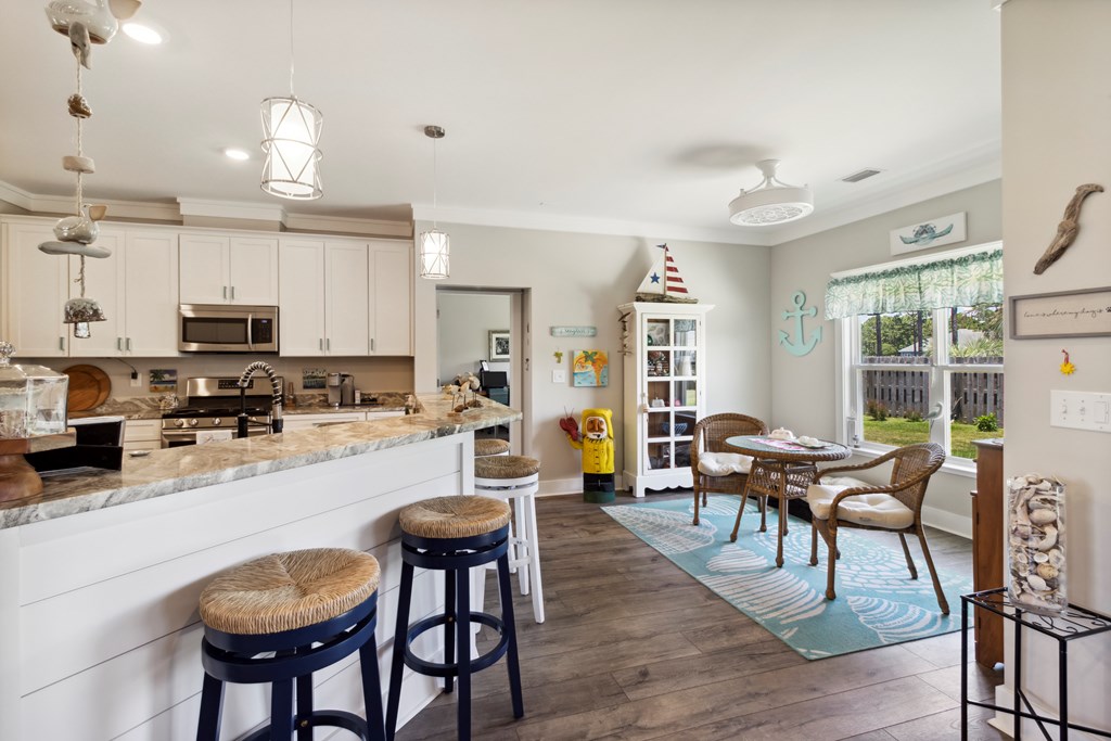 Open kitchen with a granite island and a coastal-style dining nook by the window.