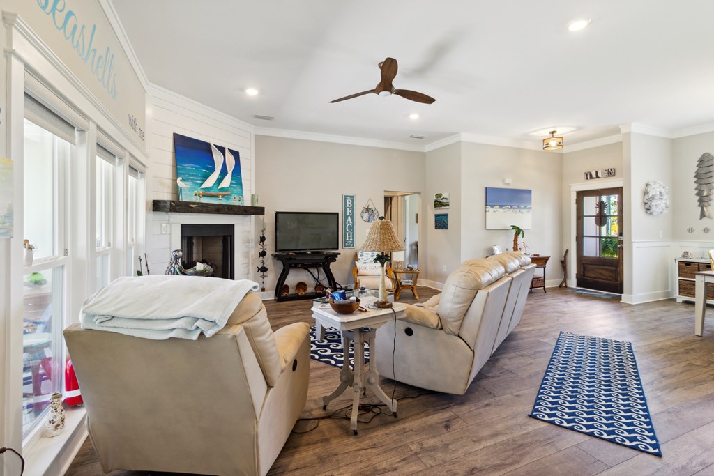 Coastal-style living room with cream sofas, a fireplace, and blue patterned rugs.