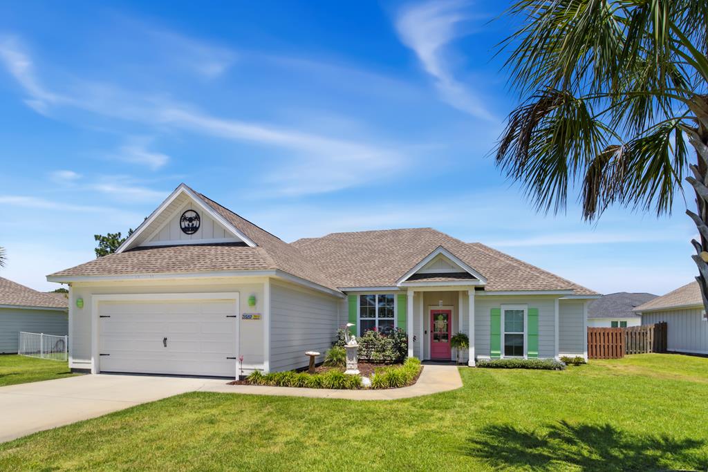 Gray single-story house with green shutters, a pink-red front door, and a white double garage.