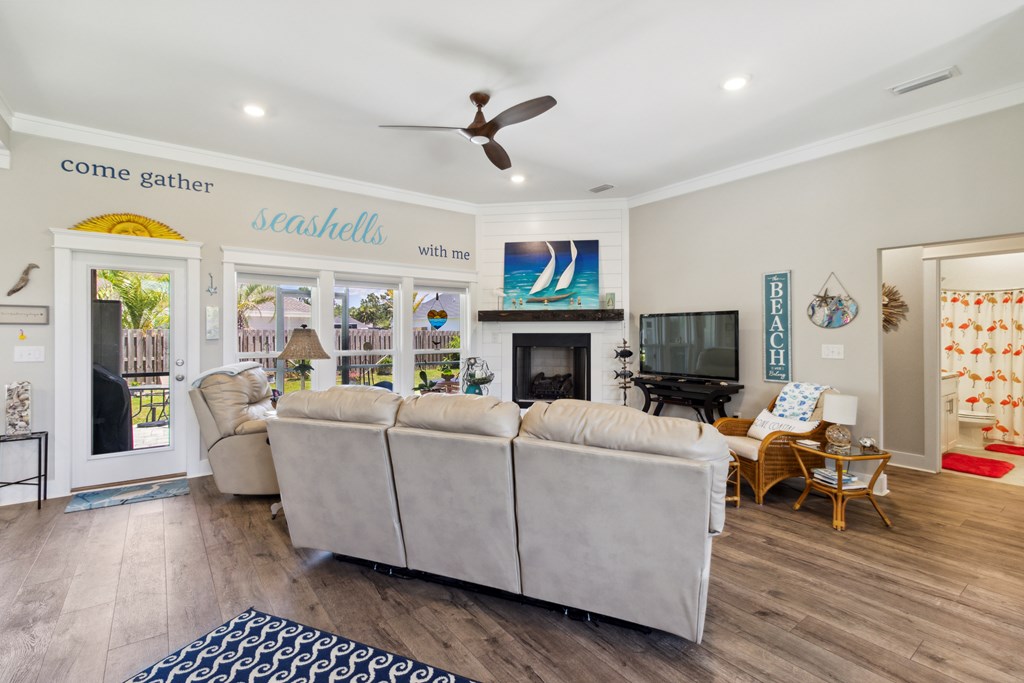 Furnished living room with a white sectional, fireplace, and large windows.