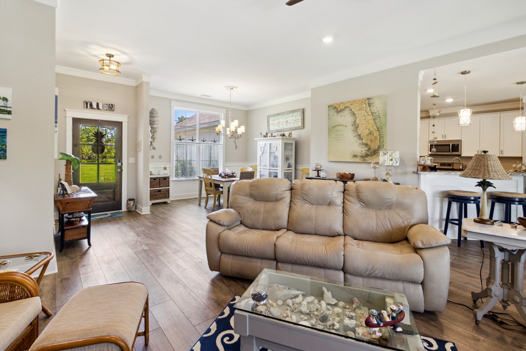Open-plan living room with a beige reclining sofa, dining area, and kitchen breakfast bar.