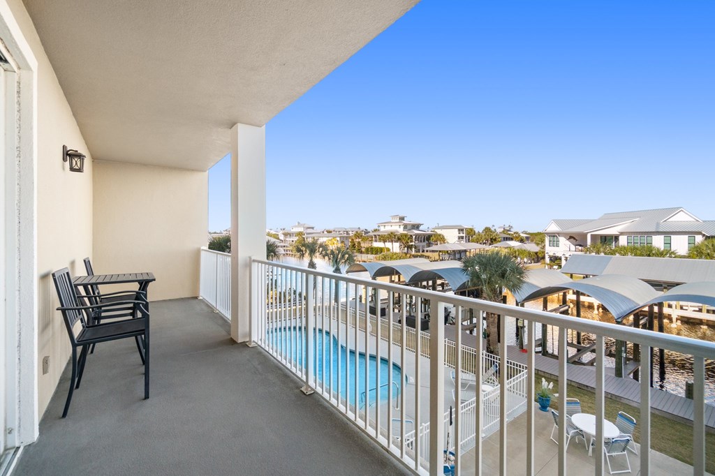 Condominium balcony overlooking a swimming pool and covered poolside seating.