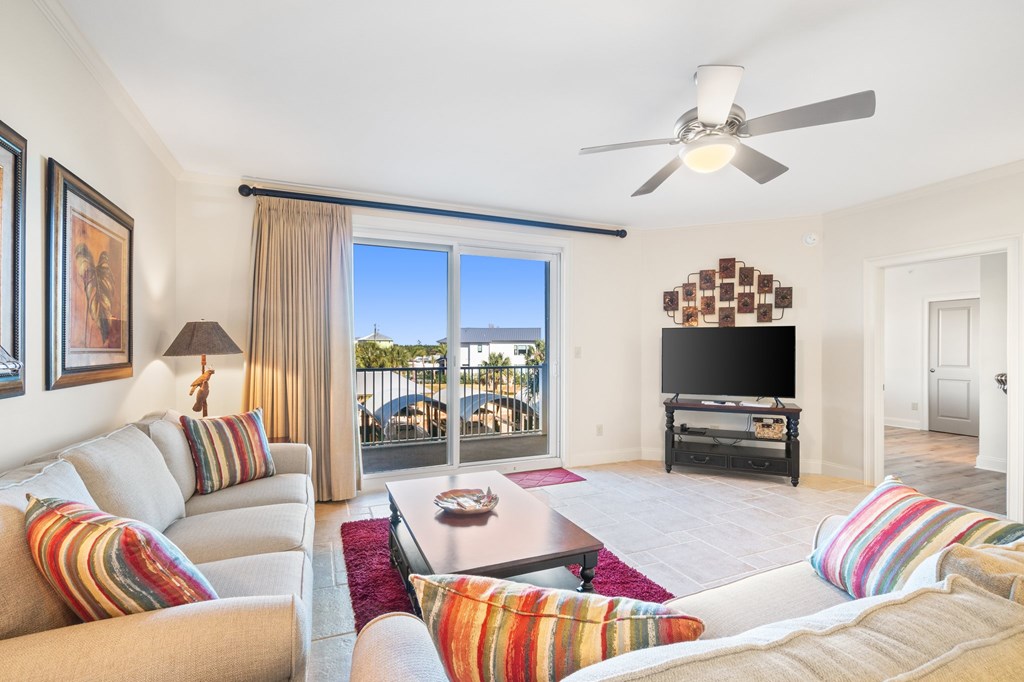 Furnished living room with colorful striped pillows and sliding glass doors to a balcony.