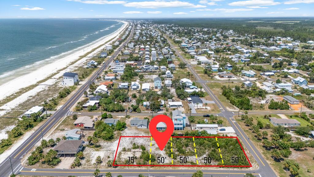 Aerial view of a marked vacant lot near the beach, with parcel boundaries and frontage measurements.