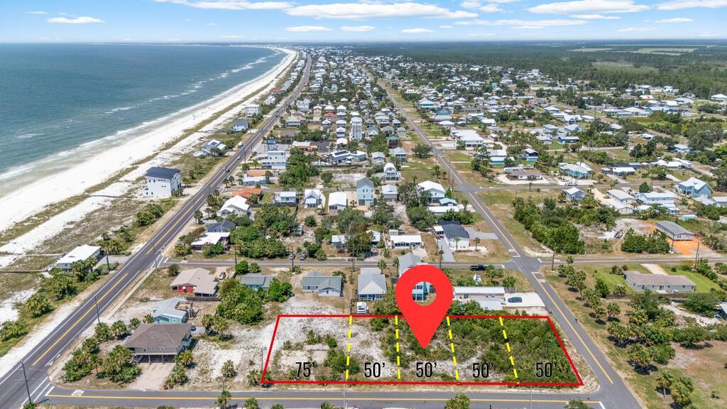 Aerial view of a vacant lot outlined with frontage measurements near the beach.