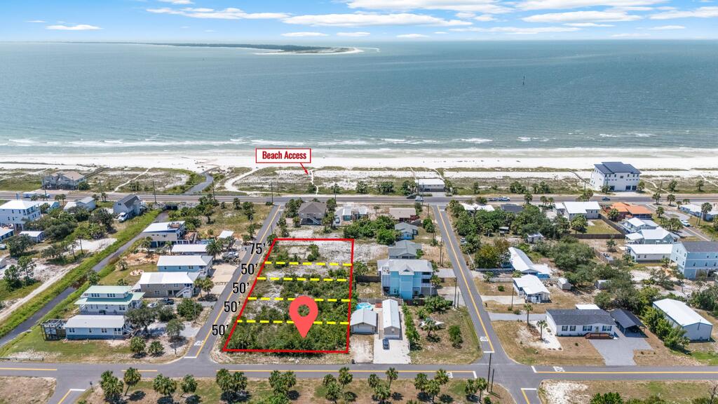 Aerial view of a vacant lot near the beach, outlined in red with the ocean beyond.