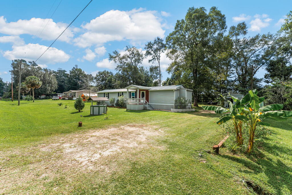 Single-story home with a small covered porch on a broad grassy lot.