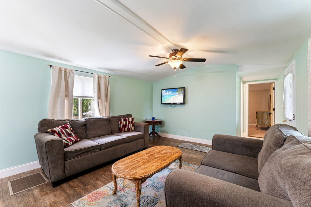 Living room with gray sofas, a wooden coffee table, and mint walls.