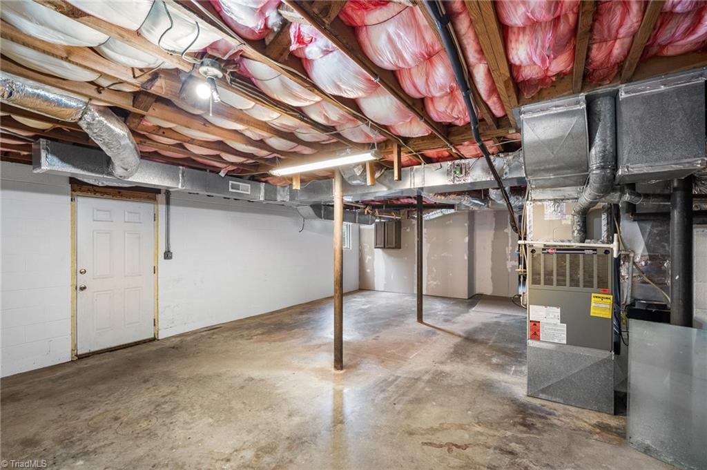 Unfinished basement with exposed insulation, ductwork, and HVAC equipment.