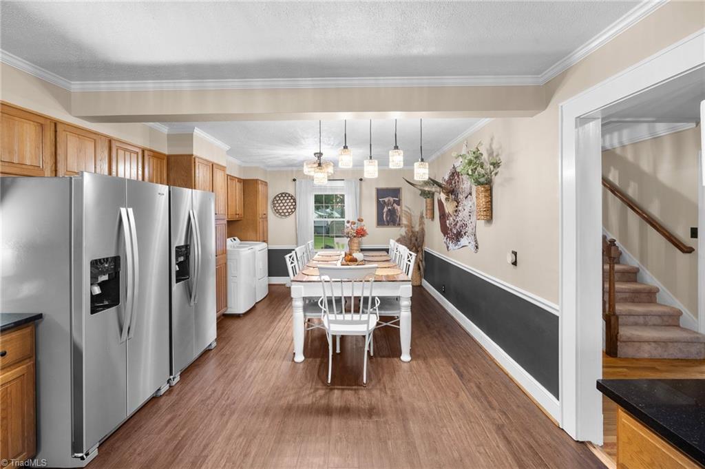Kitchen and dining area with wood cabinets, stainless steel refrigerators, and a set dining table.