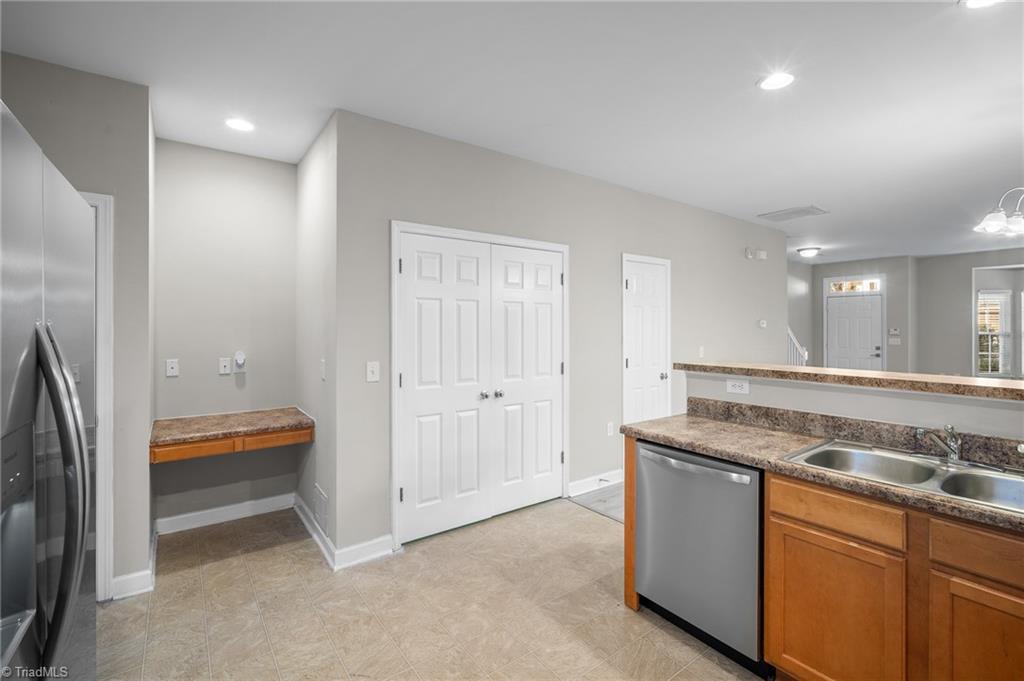 Kitchen with granite counters, wood cabinets, stainless appliances, and a small built-in counter nook.