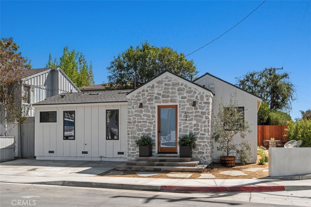 634 Glenneyre exterior with a stone entry facade, white siding, and a small patio.