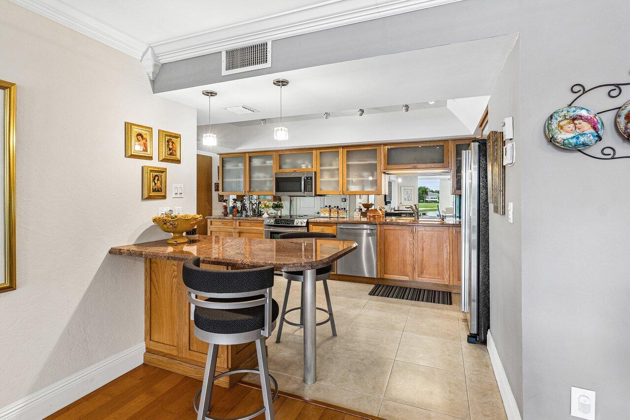 Kitchen with wood cabinetry, granite island, and stainless steel appliances.