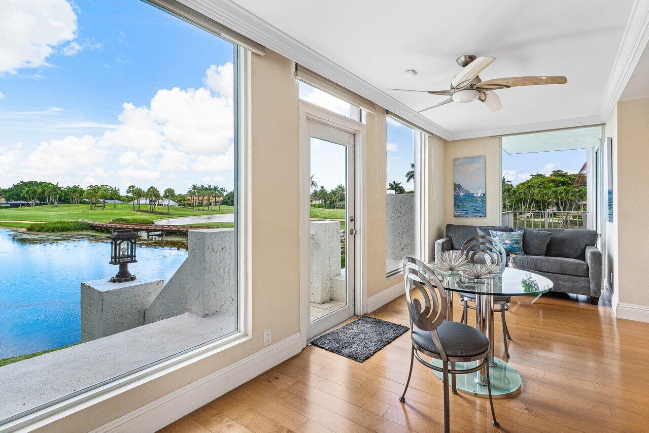 Furnished living room with wide windows overlooking water and a golf course.