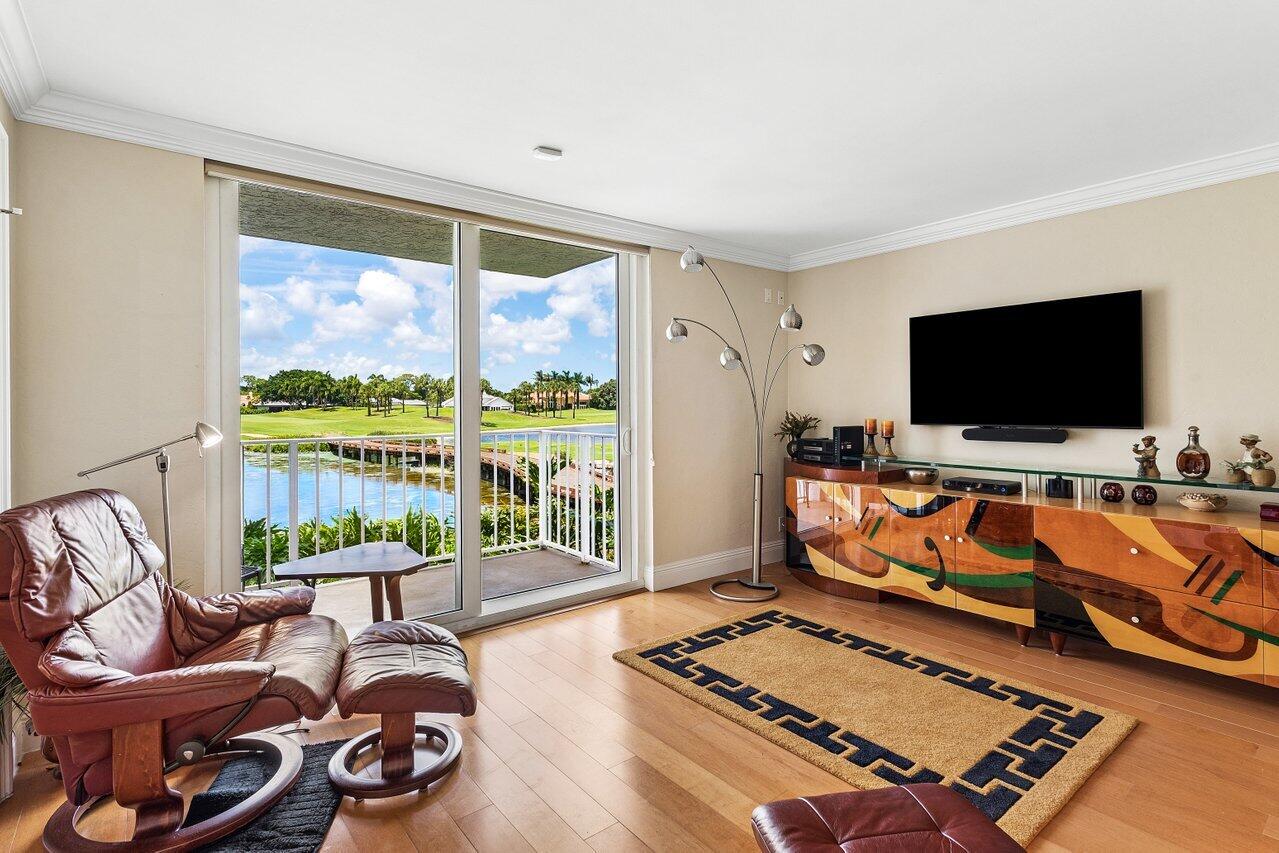 Living room with leather recliners and sliding doors overlooking a waterway and landscaped grounds.
