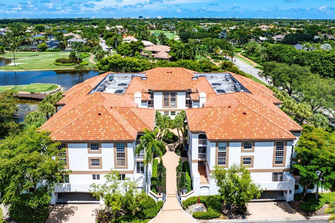 Aerial view of a condominium complex beside a lake and golf course.