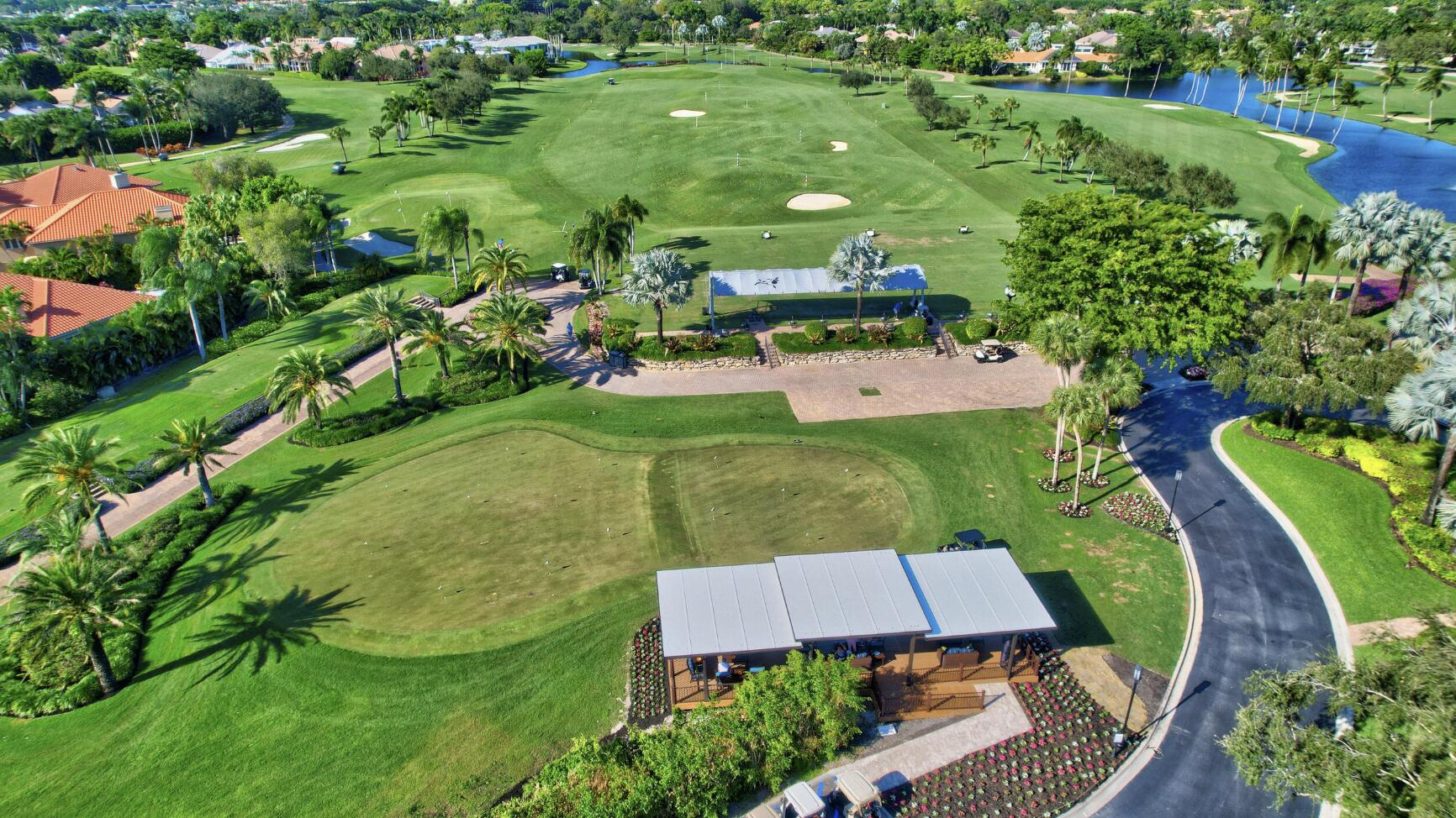 Aerial view of a golf course with putting greens, water hazards, and palm-lined paths.