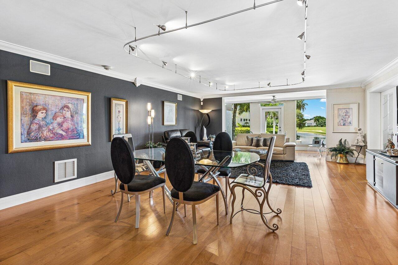 Dining and living room with glass table, hardwood floors, and a view of the water.