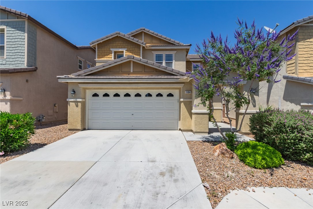 Home at 104 Big Cliff Avenue with a white double garage, wide driveway, and purple-flowering tree.