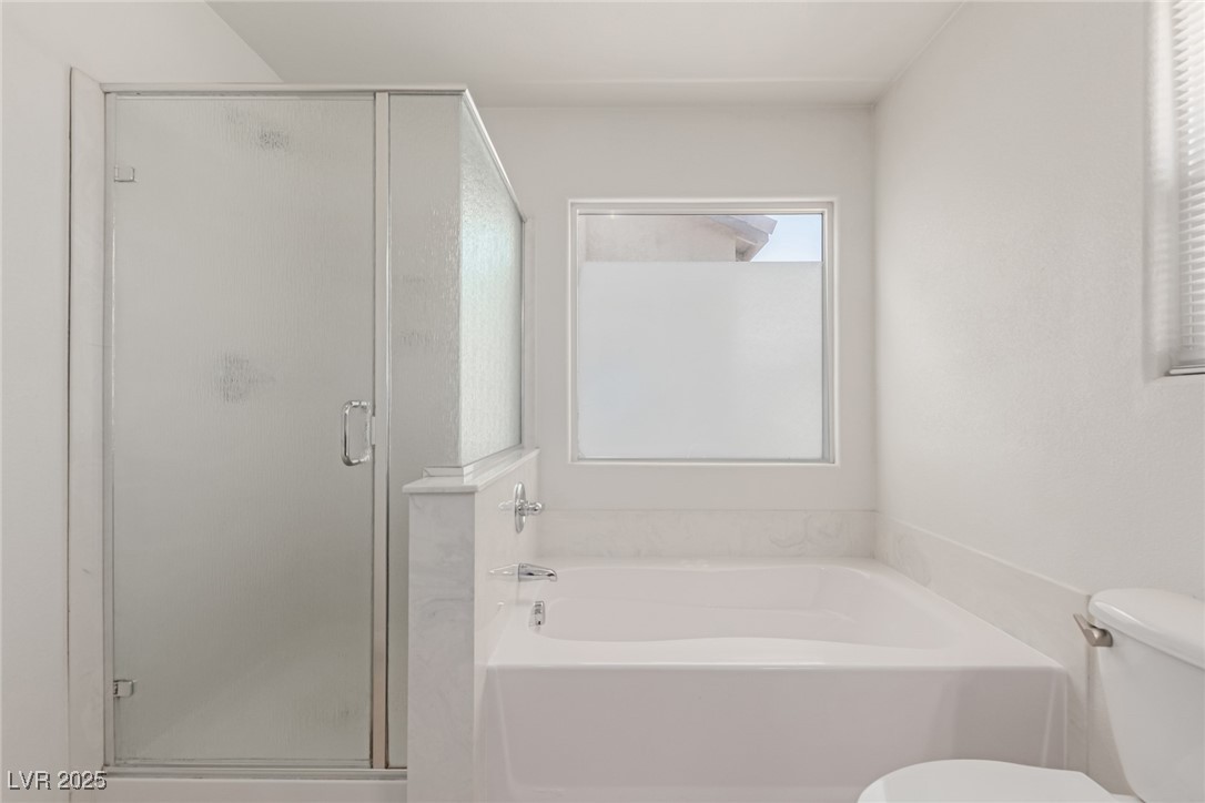 Bathroom with a large soaking tub beside a separate glass-enclosed shower.