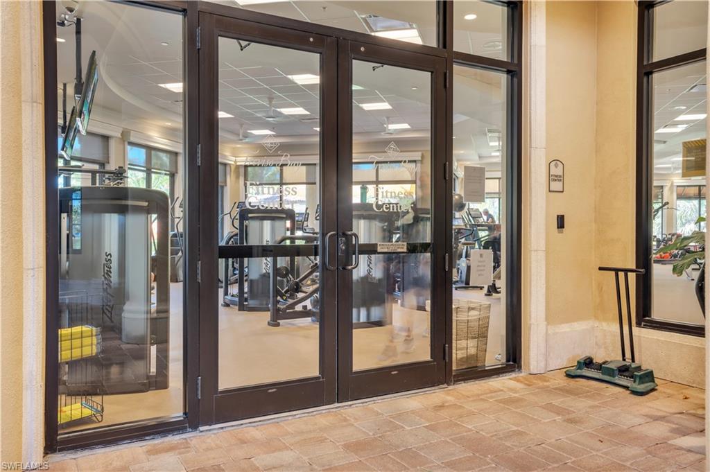 Fitness center entrance with glass doors and exercise machines visible inside.
